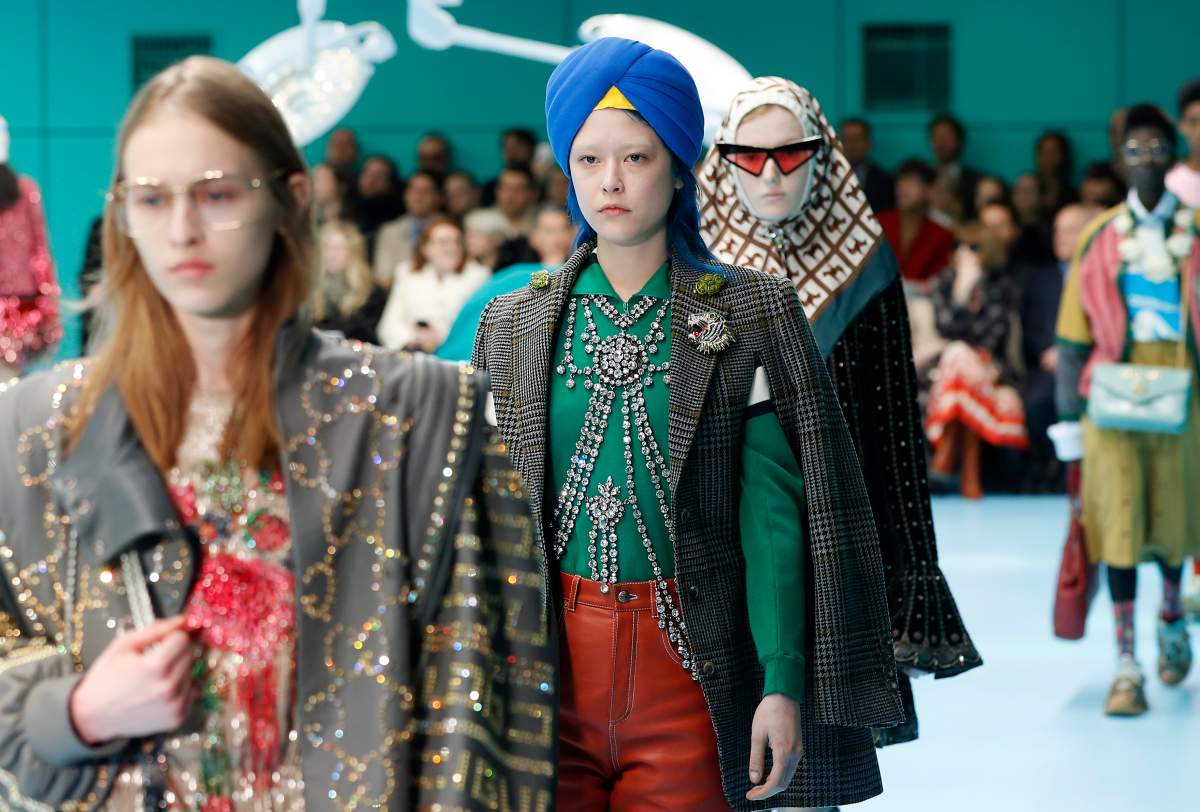 FILE - In this Feb. 21, 2018 file photo, models display items from Gucci's women's Fall/Winter 2018-2019 collection, presented during the Milan Fashion Week, in Milan, Italy.
