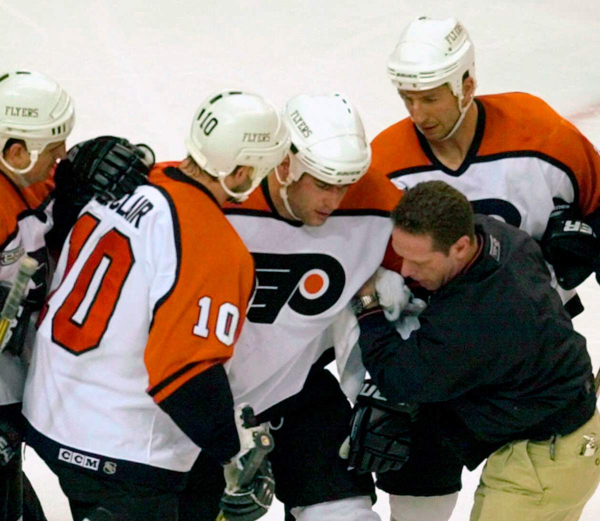 In this May 26, 2000, file photo, Philadelphia Flyers Eric Lindros, third from right, is assisted after getting hit in the first period of Game 7 of their NHL hockey Eastern Conference finals against the New Jersey Devils in Philadelphia.