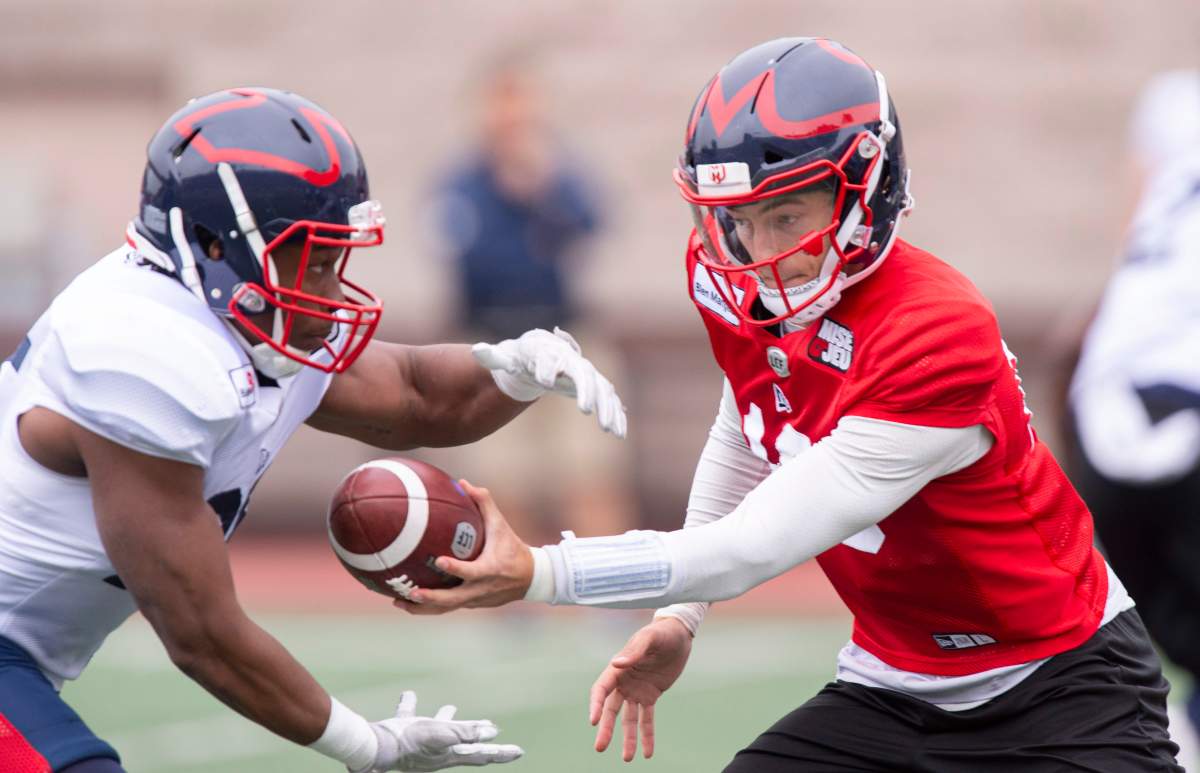 Montreal Alouettes quarterback Matthews Shiltz hands off a pass to running back Asnnelin Robo during a practice in Montreal on Monday, May 27, 2019. 