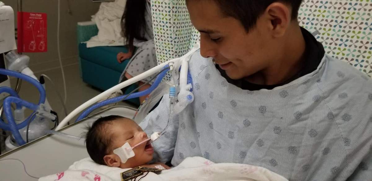 Yovany Lopez holds his infant son in hospital. Chicago police say Lopez’s pregnant wife was killed before her baby, seen above, was cut from her womb.