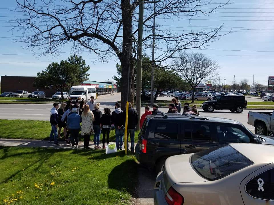 Nearly two dozen people hold a vigil for Adam Umbelina on Clarke Road just north of Dundas Street on May 8, 2019.