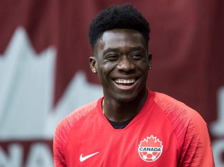 Canada's Alphonso Davies, who isn't playing due to an injury, watches as his teammates warm up before a CONCACAF Nations League qualifying soccer match against French Guiana in Vancouver, on Sunday March 24, 2019. 