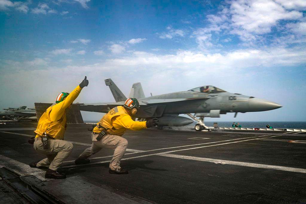 In this Thursday, May 16, 2019 photo released by the U.S. Navy, Lt. Nicholas Miller, from Spring, Texas, and Lt. Sean Ryan, from Gautier, Miss., launch an F-18 Super Hornet from the deck of the USS Abraham Lincoln aircraft carrier in the Arabian Sea.