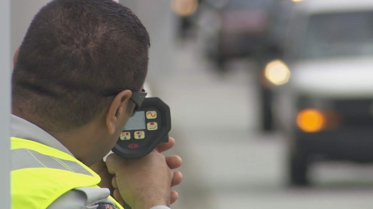 An officer aims a radar gun.