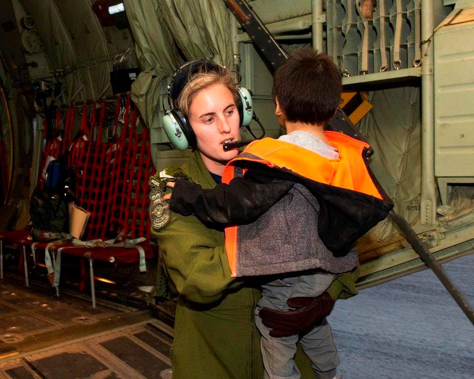 A member of the Canadian Armed Forces helps evacuate a child of the Pikangikum First Nation in Northern Ontario, as part of operation LENTUS on Thursday, May 30, 2019. Ontario's Ministry of Natural Resources says a wildfire threatening a remote Indigenous community in the province's northwest has grown several times larger.