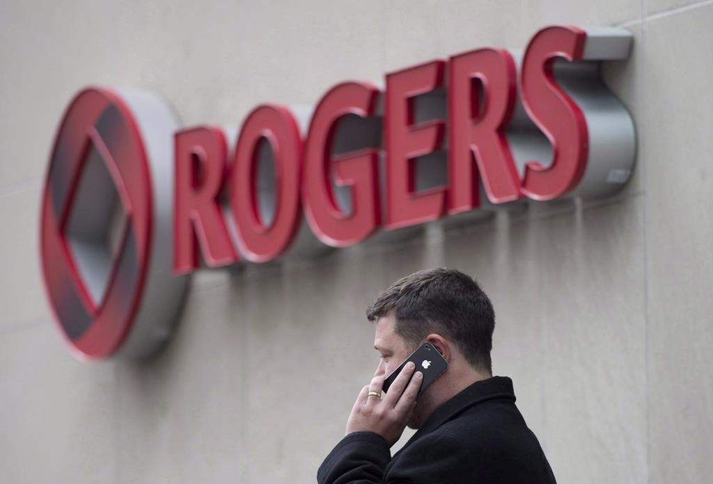 A man speaks on a mobile phone outside Rogers Communications Inc.'s annual general meeting of shareholders in Toronto on April 22, 2014. THE CANADIAN PRESS/Darren Calabrese.