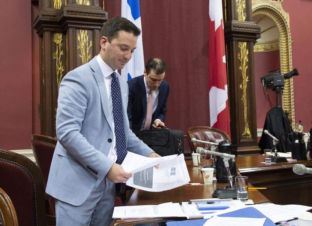 Quebec Minister of Immigration, Diversity and Inclusiveness Simon Jolin-Barrette picks up documents on the first day of a legislature committee studying a bill on secularism, Tuesday, May 7, 2019 at the legislature in Quebec City. Hearings into Quebec's secularism bill veered off track Thursday when a former senator drew a connection between the Muslim head scarf, female genital mutilation and forced marriage.