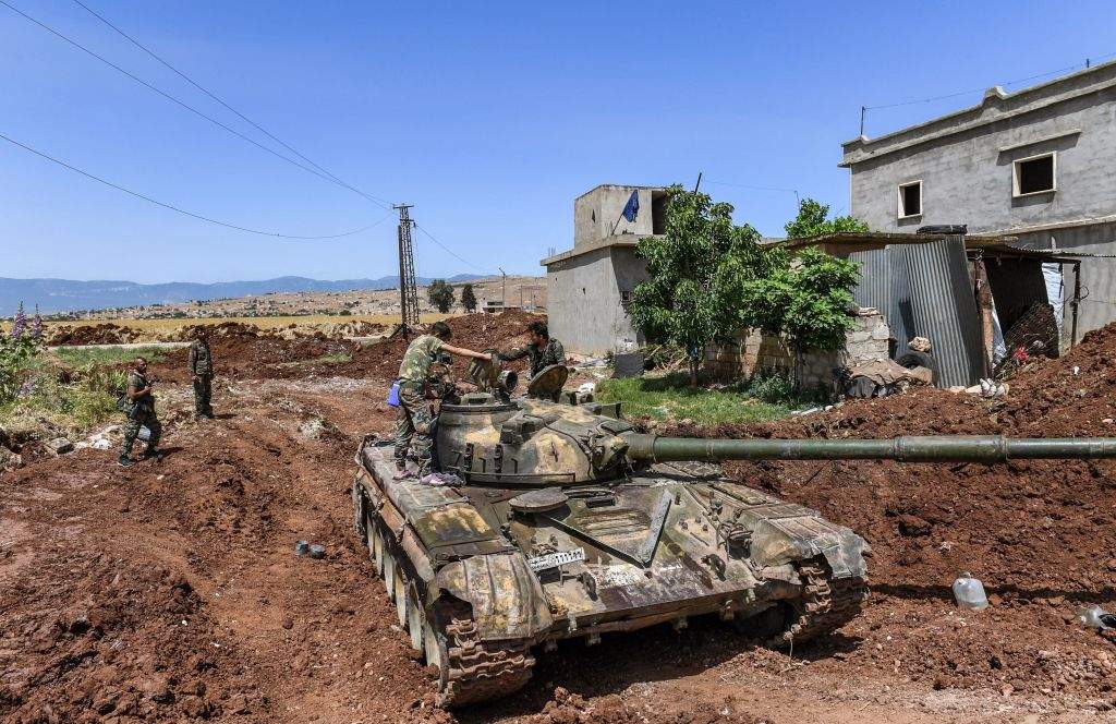 Syrian soldiers stand atop a tank in the village of al-Jabiriya in the northern countryside of Hama province on May 25, 2019. 