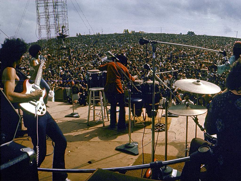 Carlos Santana (L) and his band perform onstage to a huge audience at the Woodstock Music & Art Festival, Bethel, N.Y., on Aug. 16, 1969.