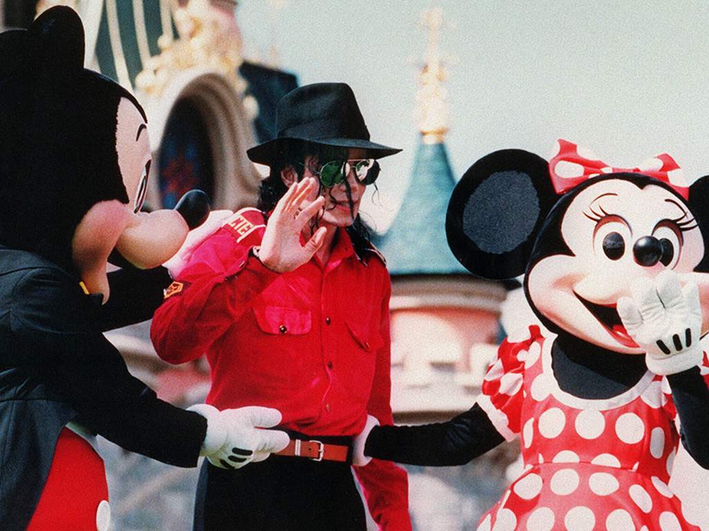 Michael Jackson, flanked by Mickey Mouse and Minnie, waves to fans July 27, 1992 during his suprise visit to the EuroDisney.