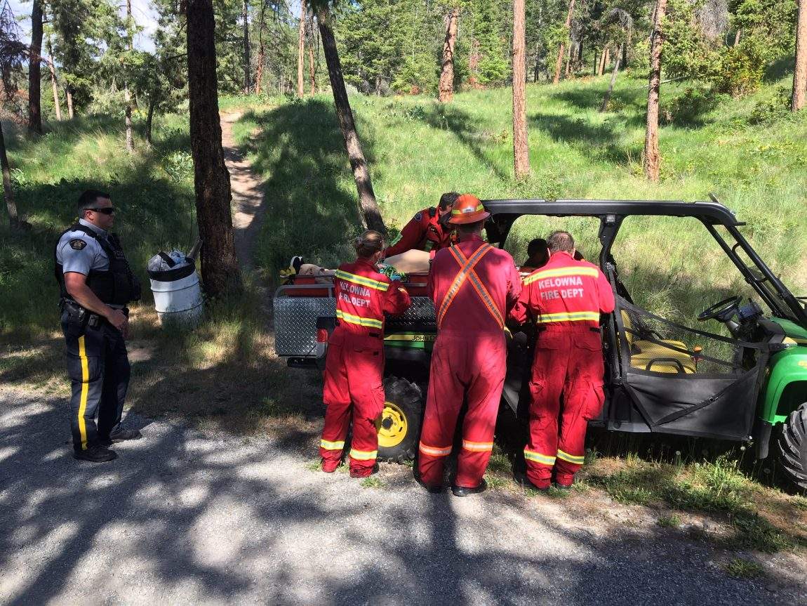 Rescue crews load a woman onto an ATV near Knox Mtn. Park in Kelowna. 