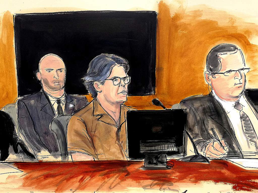 In this April 13, 2018 courtroom sketch, Keith Raniere, centre, leader of NXIVM, attends a hearing at court in New York.