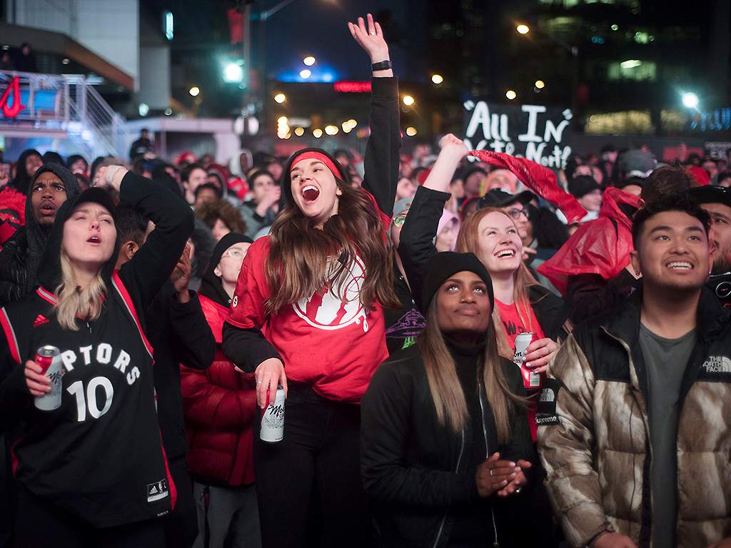 In this May 12, 2019, photo, basketball fans cheer for the Toronto Raptors before claiming victory over the Philadelphia 76ers outside Maple Leaf Square in Toronto.