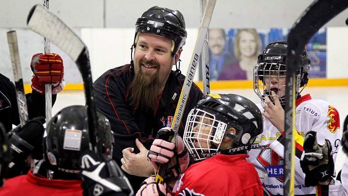 Hockey Education Reaching Out Society (HEROS) program manager Kevin Hodgson, centre, works with disadvantaged kids during an on-ice session in Calgary, Alta., Dec. 20, 2012.