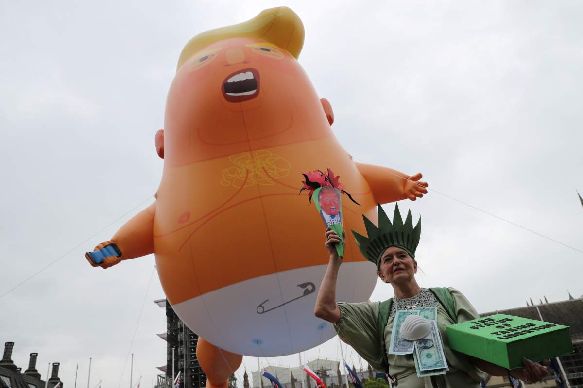 A “Baby Trump” balloon flies over a demonstrator as she takes part in an anti-Trump protest in London, Britain, June 4, 2019.