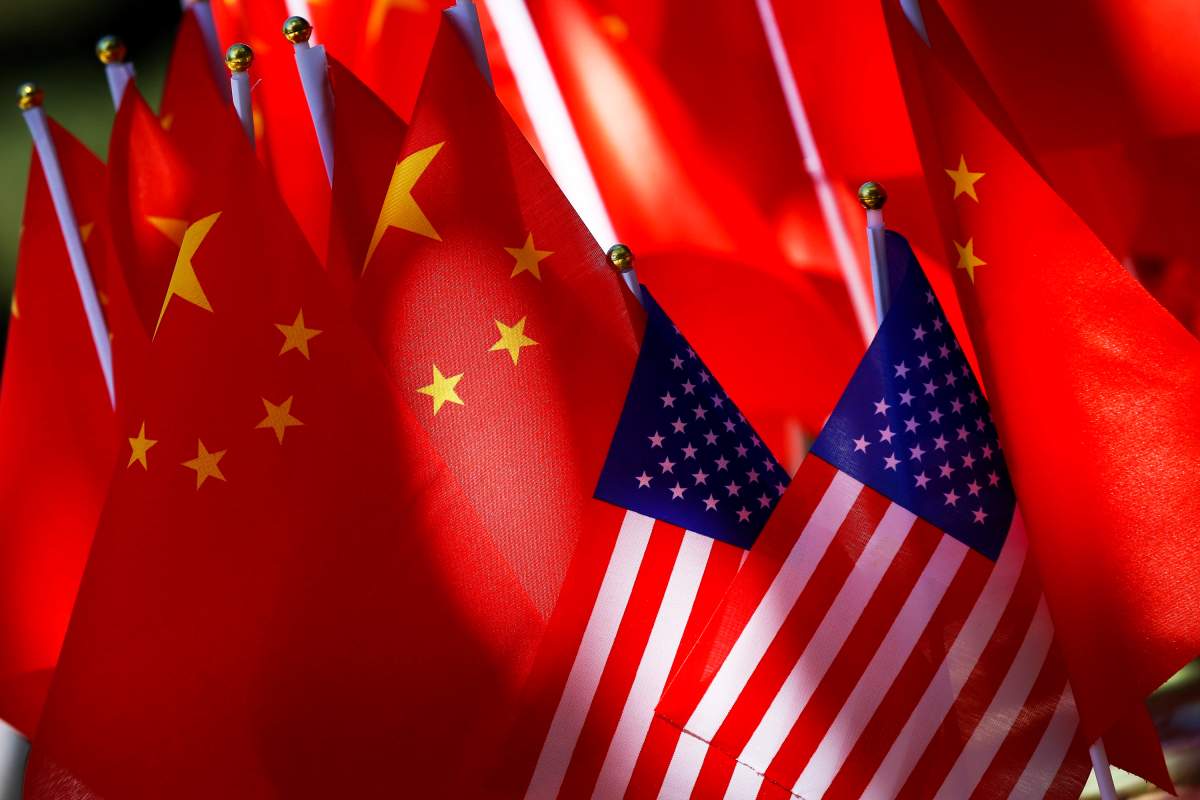 FILE - In this Sept. 16, 2018, file photo, American flags are displayed together with Chinese flags on top of a trishaw in Beijing.