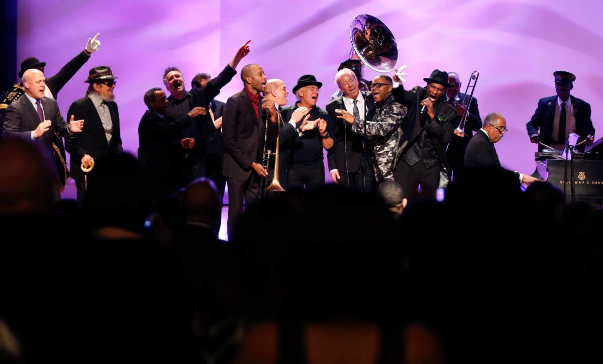 In this Friday, Nov. 20, 2015 file photo, Dr. John, second left, joins a plethora of legendary New Orleans musicians and speakers, including New Orleans Mayor Mitch Landrieu, John Boutte, John Cleary, Deacon John Moore, Jimmy Buffett, Boz Scaggs, Cyril Neville and the Preservation Hall Jazz Band, at a tribute for legendary New Orleans composer and recording artist Allen Toussaint, in New Orleans. (AP Photo/Gerald Herbert, File)