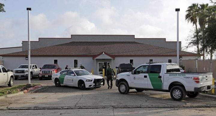 In this Saturday, June 23, 2018, file photo, a U.S. Border Patrol Agent walks between vehicles outside the Central Processing Center in McAllen, Texas. 