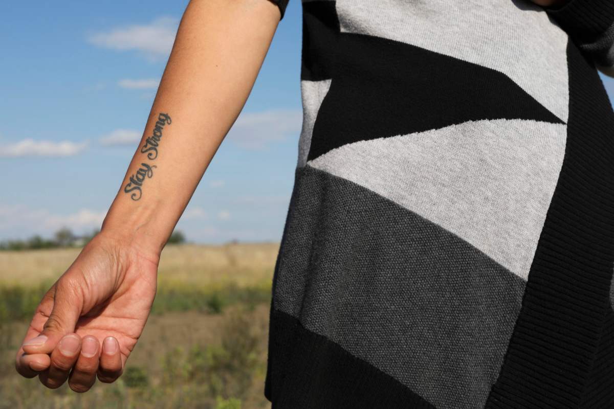 A woman who is the mother of a victim in the 2016 La Loche shooting, shows her tattoo in support of her son who was shot in the arm, in Saskatoon, Wednesday, June 12, 2019.