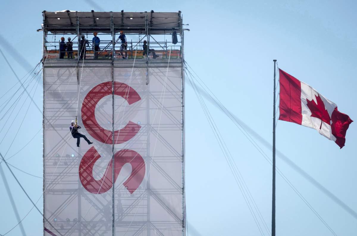 A visitor slides down a zip line during the Calgary Stampede in Calgary, Sunday, July 8, 2018. 