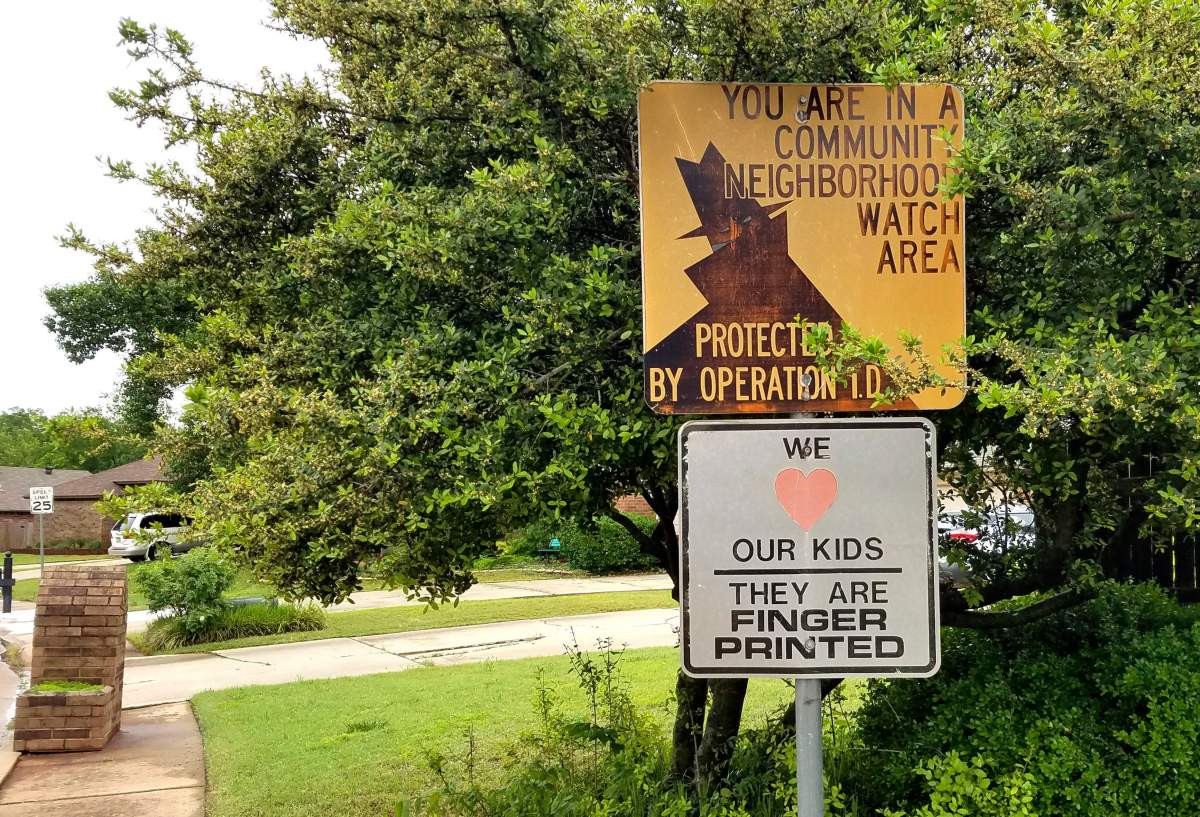 In this May 1, 2019 file photo, a neighbourhood watch sign stands at the entry to the Edmond, Okla., neighborhood where police fatally shot Isaiah Lewis after forcing his way inside a home. 