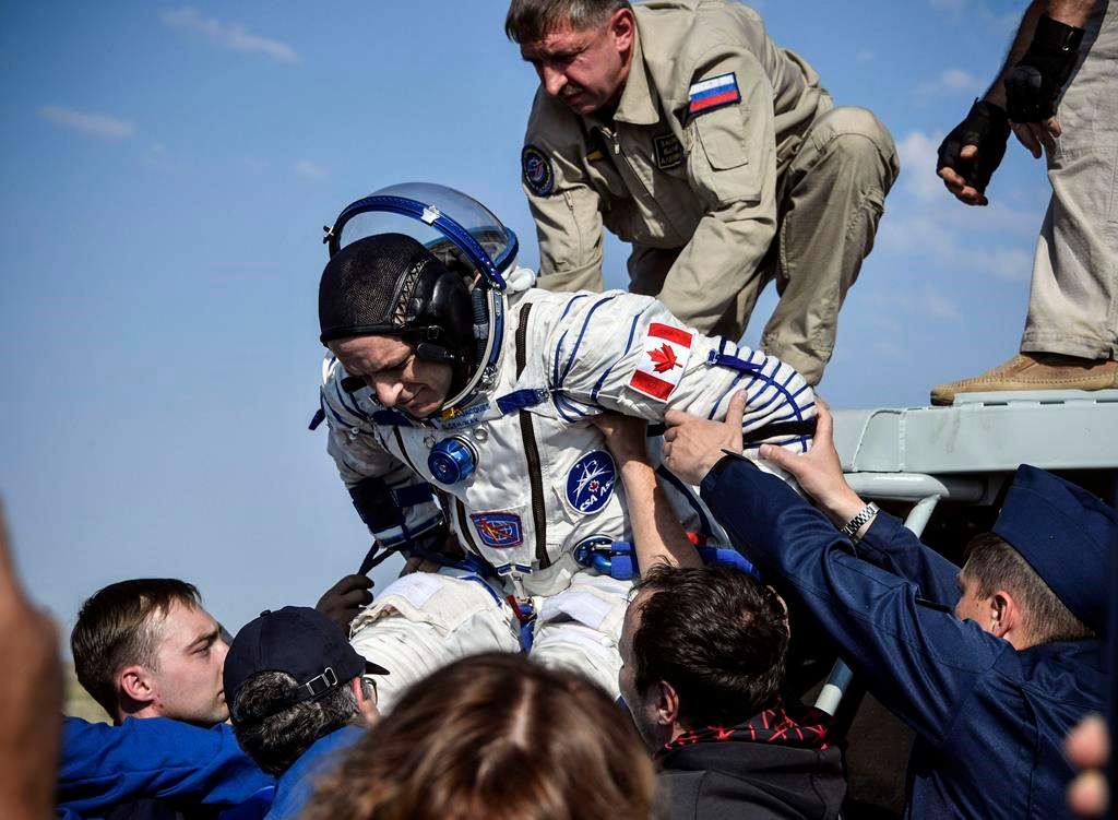 A Russian space agency rescue team helps astronaut David Saint-Jacques get out of the capsule shortly after the landing of the Russian Soyuz MS-11 space capsule about 150 kilometres southeast of the Kazakh town of Zhezkazgan, Kazakhstan, Tuesday, June 25, 2019.