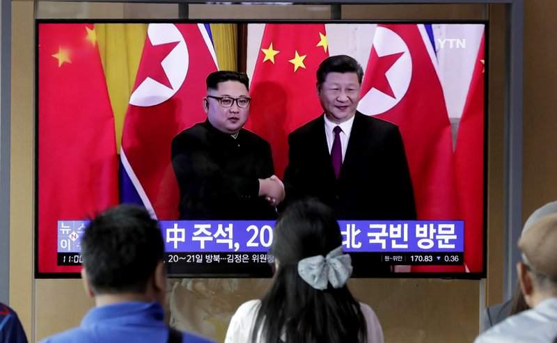 In this June 18, 2019 photo, people watch a TV news program reporting about Chinese President Xi Jinping's state visit to North Korea with a file footage of Chinese President Xi Jinping and North Korean leader Kim Jong Un, at the Seoul Railway Station in Seoul, South Korea. From nukes to huge food aid shipments to a shared skepticism about the United States, Xi and Kim will have a long list of topics to discuss when Xi heads north Thursday, June 20.