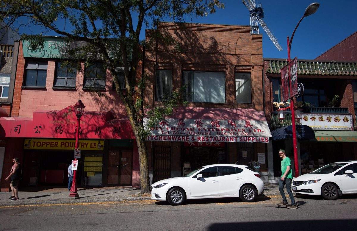 A man rides a skateboard past businesses in Chinatown in Vancouver, B.C., on Thursday August 18, 2016. Advocates of small businesses are calling on the B.C. government to change its rules for the employer health tax as payments start coming in on Saturday, June 15, 2019.