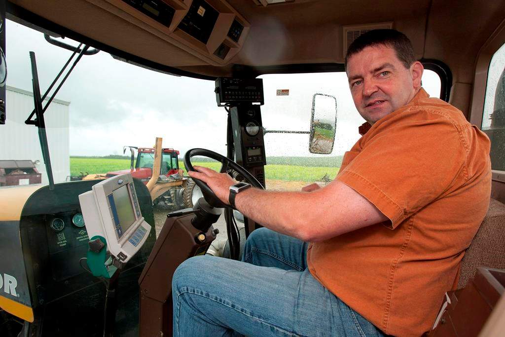New Brunswick potato farmer Henk Tepper sits inside a tractor Tuesday, June 26, 2012 at his farm in Drummond, N.B.