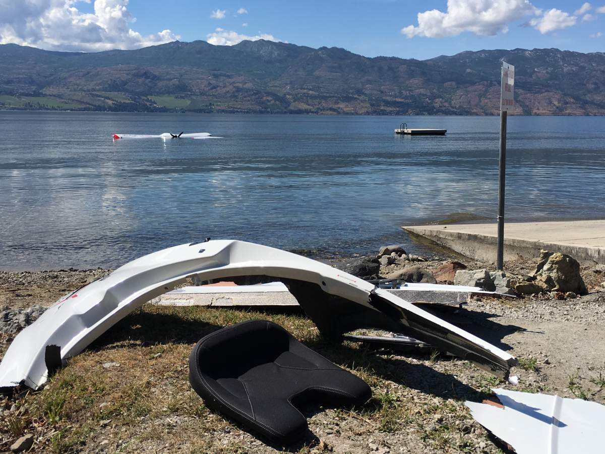 Debris from the float plane crash was still on the beach in West Kelowna one day after the aviation incident. The float plane itseld can be seen in the water in the background.