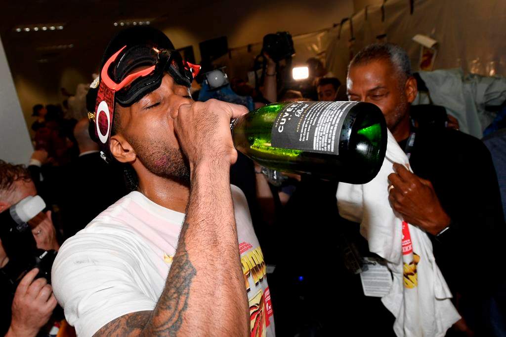 Toronto Raptors forward Kawhi Leonard (2) drinks champagne as he celebrates defeating the Golden State Warriors and winning the Larry O’Brien NBA Championship Trophy after Game 6 basketball action in Oakland, Calif. on Thursday, June 13, 2019.
