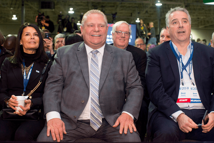 Ontario Premier Doug Ford, centre, sits alongside his wife Karla and Chief of Staff Dean French as they prepare to hear Federal Conservative Leader Andrew Scheer speak at the Ontario PC Convention in Toronto on Saturday, November 17, 2018.