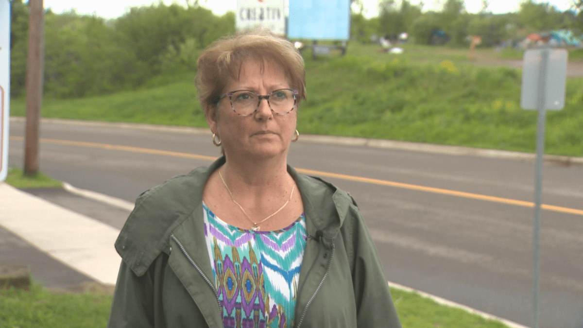 Guylaine Landry, the owner of Building Futures Early Child Care Centre, stands on the walkway of her business with a tent camp across the street that she says has impacted her business