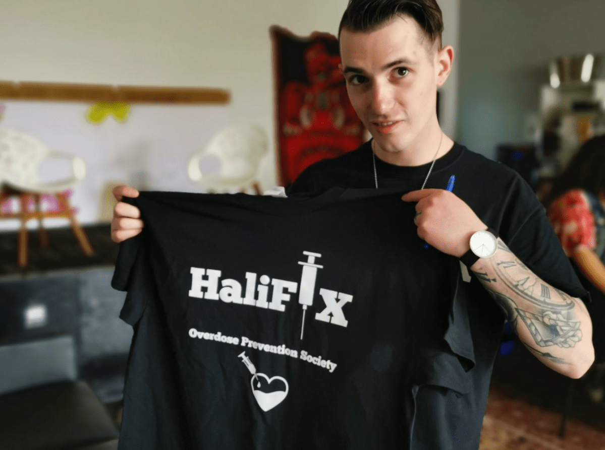 Matthew Bonn, president of the HaliFIX Overdose Prevention Society, holds up one of the society’s T-shirts at a Naxolone training session in Halifax on Saturday, June 1, 2019.