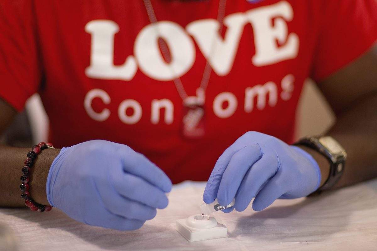 A free HIV test is administered by an Atlanta AIDS advocacy group volunteer in this June 27, 2013 file photo. Vancouver Coastal Health says the number of new HIV cases within its boundaries has dropped to its lowest level since 2003.