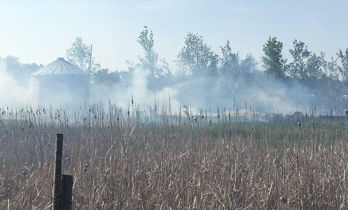 A grass fire burns south of the perimeter highway Tuesday.