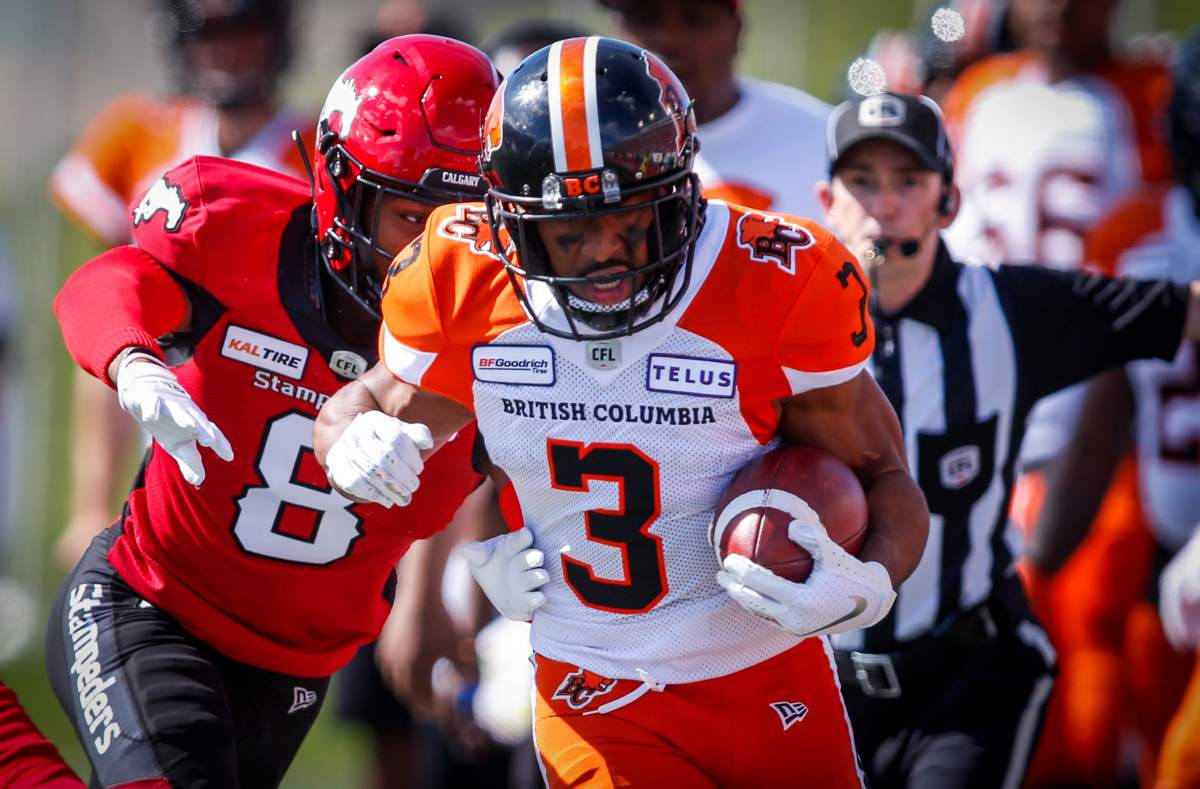 B.C. Lions' John White IV, right, runs the ball out of bounds as Calgary Stampeders' DaShaun Amos chases during first half CFL football action in Calgary, Saturday, June 29, 2019. 