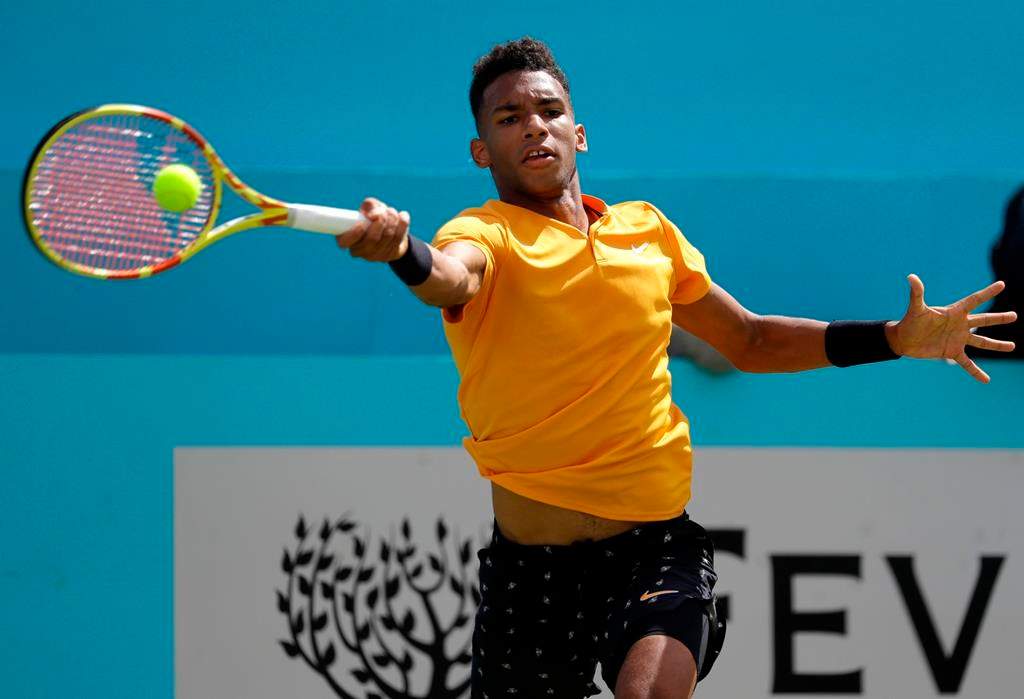 Felix Auger-Aliassime of Canada plays a return to Stefanos Tsitsipas of Greece during their quarterfinal singles match at the Queens Club tennis tournament in London, Friday, June 21, 2019.