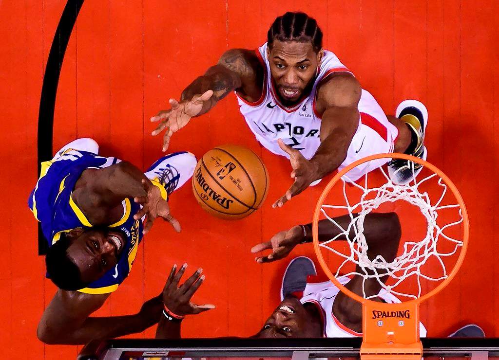Toronto Raptors forward Pascal Siakam (43) and Toronto Raptors forward Kawhi Leonard (2) eye the ball against Golden State Warriors forward Draymond Green (23) during the second half of Game 2 of the NBA Finals in Toronto on Sunday, June 2, 2019.