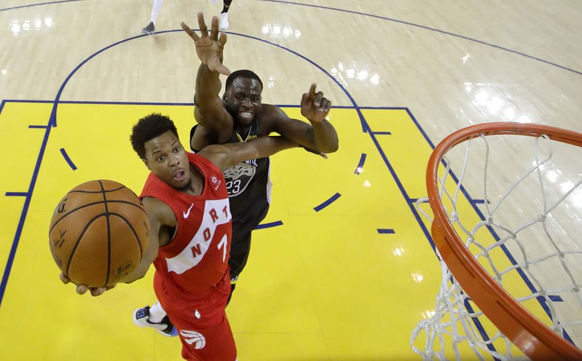 Toronto Raptors guard Kyle Lowry (7) shoots in front of Golden State Warriors forward Draymond Green during the second half of Game 4 of basketball's NBA Finals in Oakland, Calif., Friday, June 7, 2019.