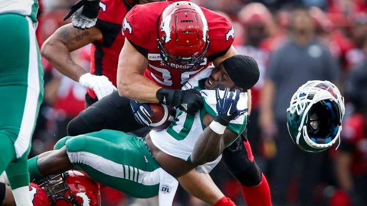 Saskatchewan Roughriders' James Butler, right, loses his helmet as he is hit by Calgary Stampeders' Cory Greenwood during CFL pre-season football action in Calgary May 31, 2019.