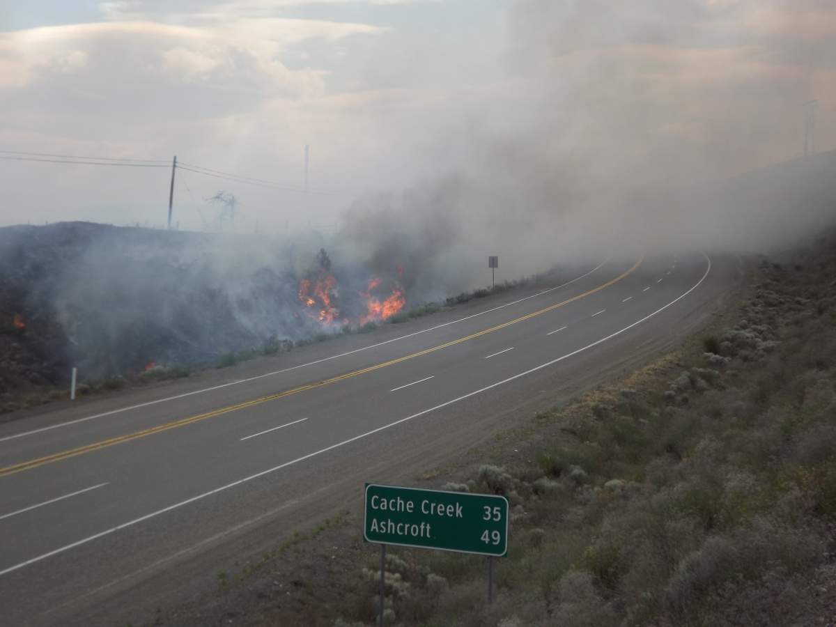 A wildfire can be seen shooting up from the side of Highway 1 near Savona, B.C. on Wednesday, June 5, 2019.