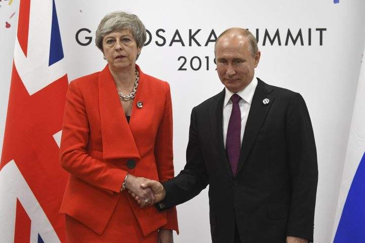 Russian President Vladimir Putin, right, and British Prime Minister Theresa May shake hands during their meeting on the sidelines of the G-20 summit in Osaka, western Japan, Friday, June 28, 2019.