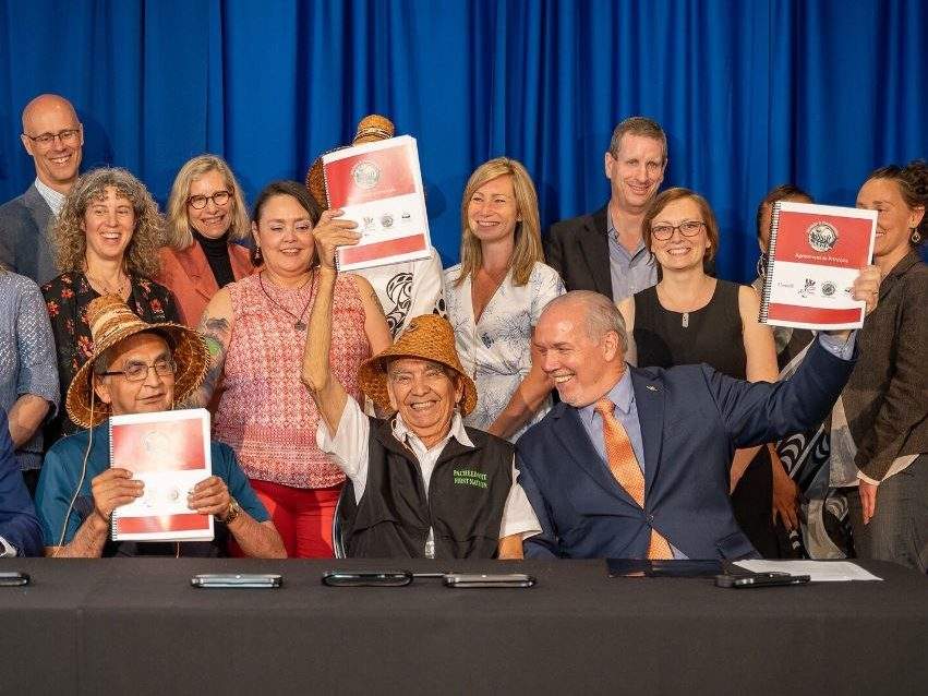 Premier John Horgan holds up a treaty in principle along with Ditidaht First Nation Chief Robert Joseph (left) and Pacheedaht First Nation Chief Jeff Jones on Friday, June 28, 2019.