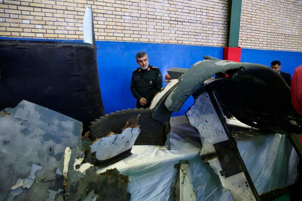 Head of the Revolutionary Guard’s aerospace division Gen. Amir Ali Hajizadeh looks at debris from what the division describes as the U.S. drone which was shot down on Thursday, in Tehran, Iran, Friday, June 21, 2019. (Meghdad Madadi/Tasnim News Agency/via AP)