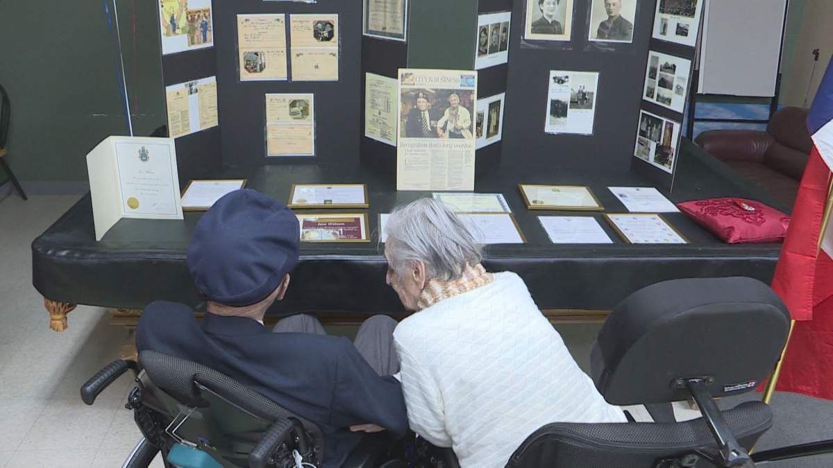 Ian and Betty Wilson looking at a collection of photos and recognition letters the couple has received over the years.