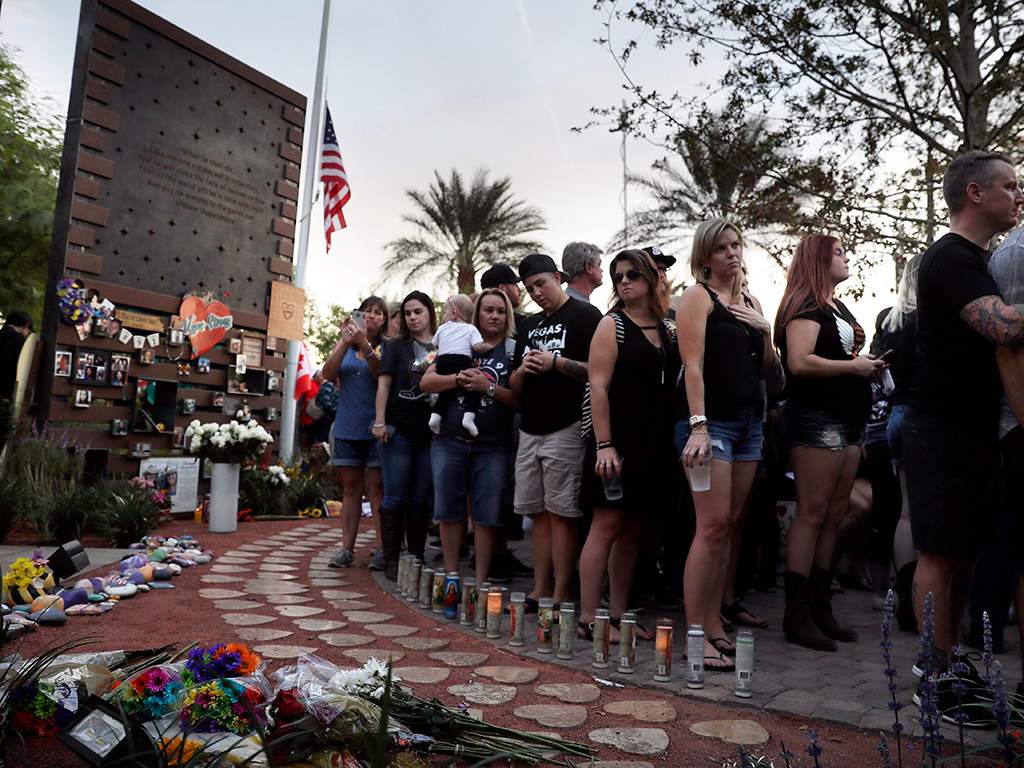 People gather to dedicate a healing garden on the first anniversary of the Oct. 1, 2017 shooting that killed 58 people and wounded hundreds, in Las Vegas, Nev.