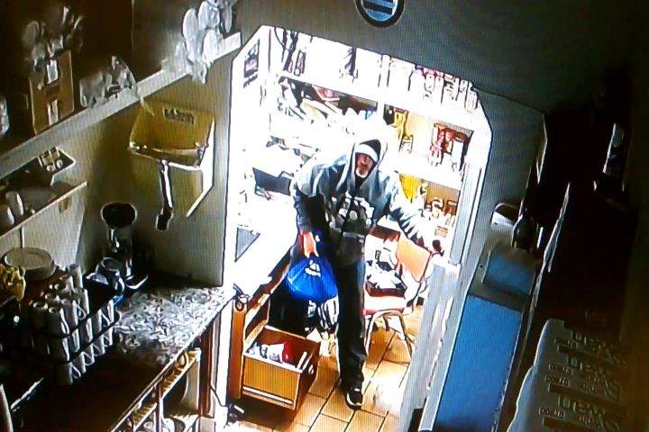 Surveillance footage showed a suspect wearing a black baseball hat, a grey hoodie, blue jeans, red gloves and dark shoes, police say.
