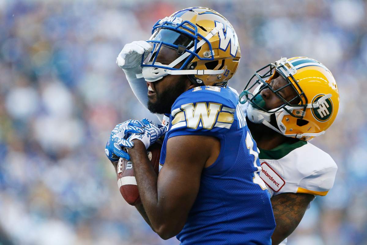 Winnipeg Blue Bombers' Chris Matthews (13) can't hang onto the pass as Edmonton Eskimos' Forrest Hightower (12) gets his hand on Matthews' mask during the first half of CFL action in Winnipeg Thursday, June 27, 2019. 