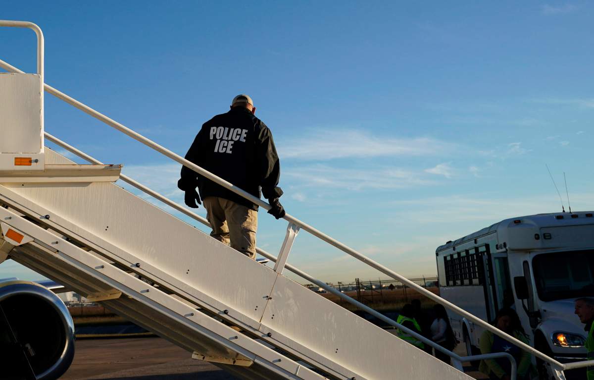  In this Nov. 16, 2018, file photo, an officer watches as immigrants who entered the United States illegally are deported on a flight to El Salvador by U.S. Immigration and Customs Enforcement in Houston.